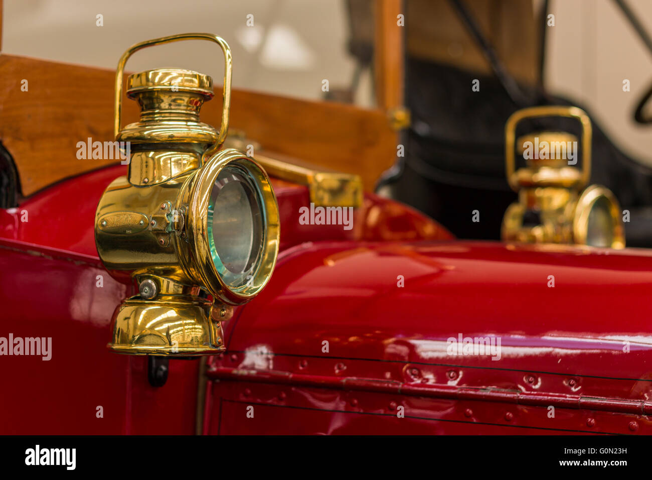 Brass side head lamp on a red 1910 Austin vintage car Stock