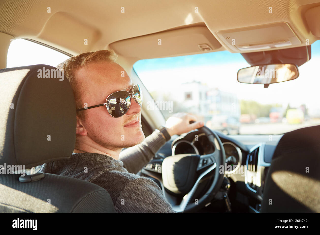 Handsome man driving car wearing sunglasses Stock Photo Alamy