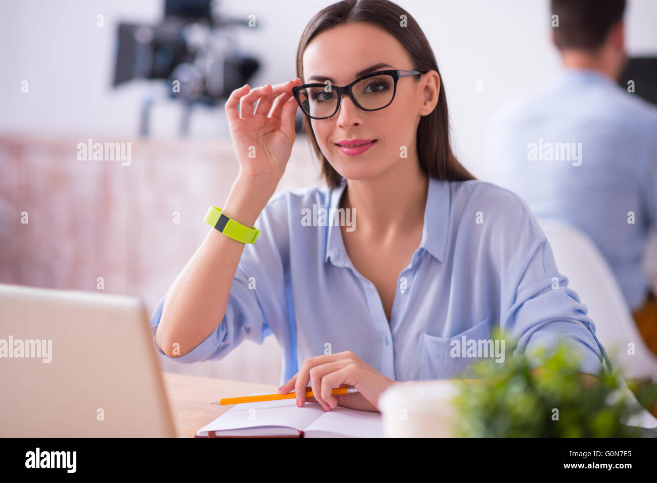 Pleasant woman sitting at the table Stock Photo - Alamy