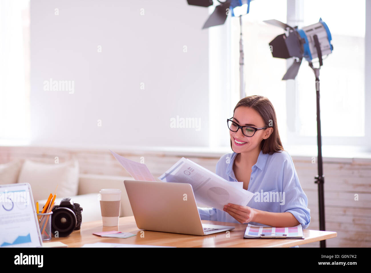Pleasant woman sitting at the table Stock Photo - Alamy