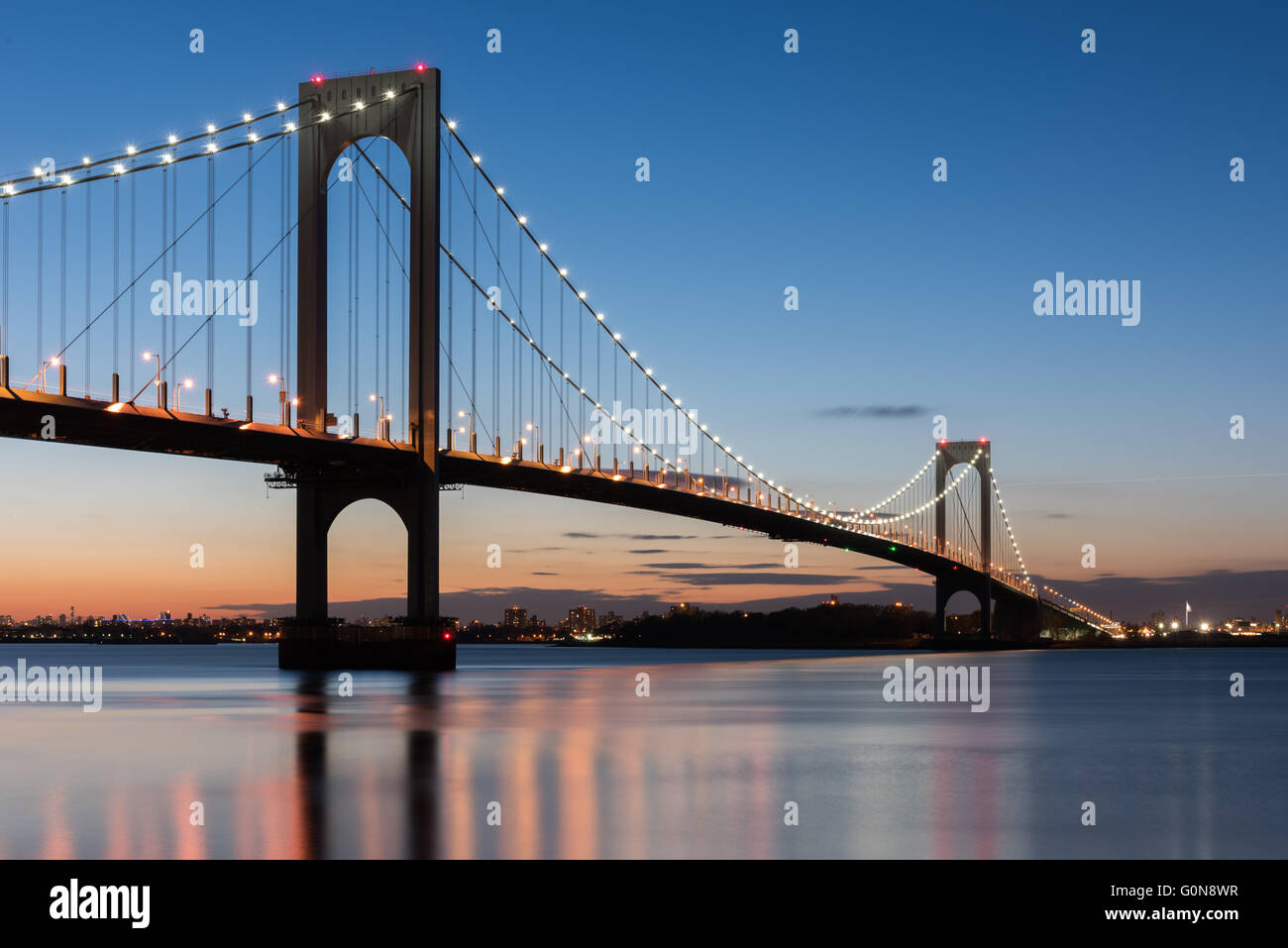 The BronxWhitestone Bridge reflecting on the East River at night in