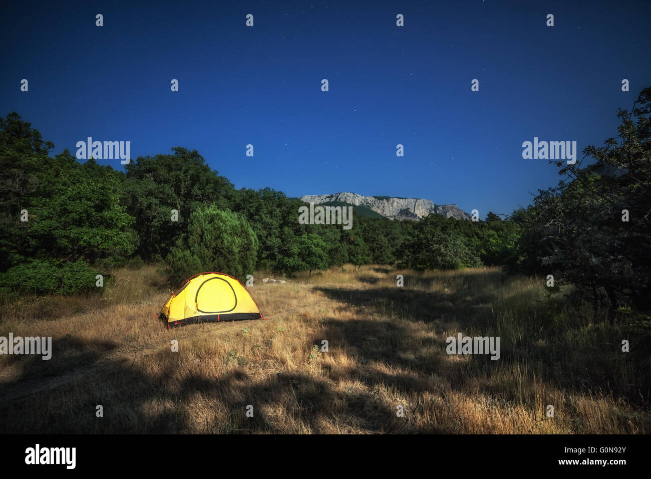 Yellow tent on meadow in summer Stock Photo