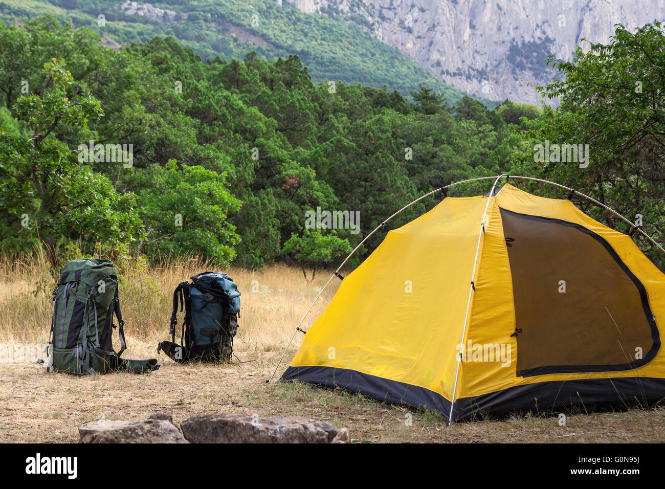 Two backpacks and tent on meadow Stock Photo