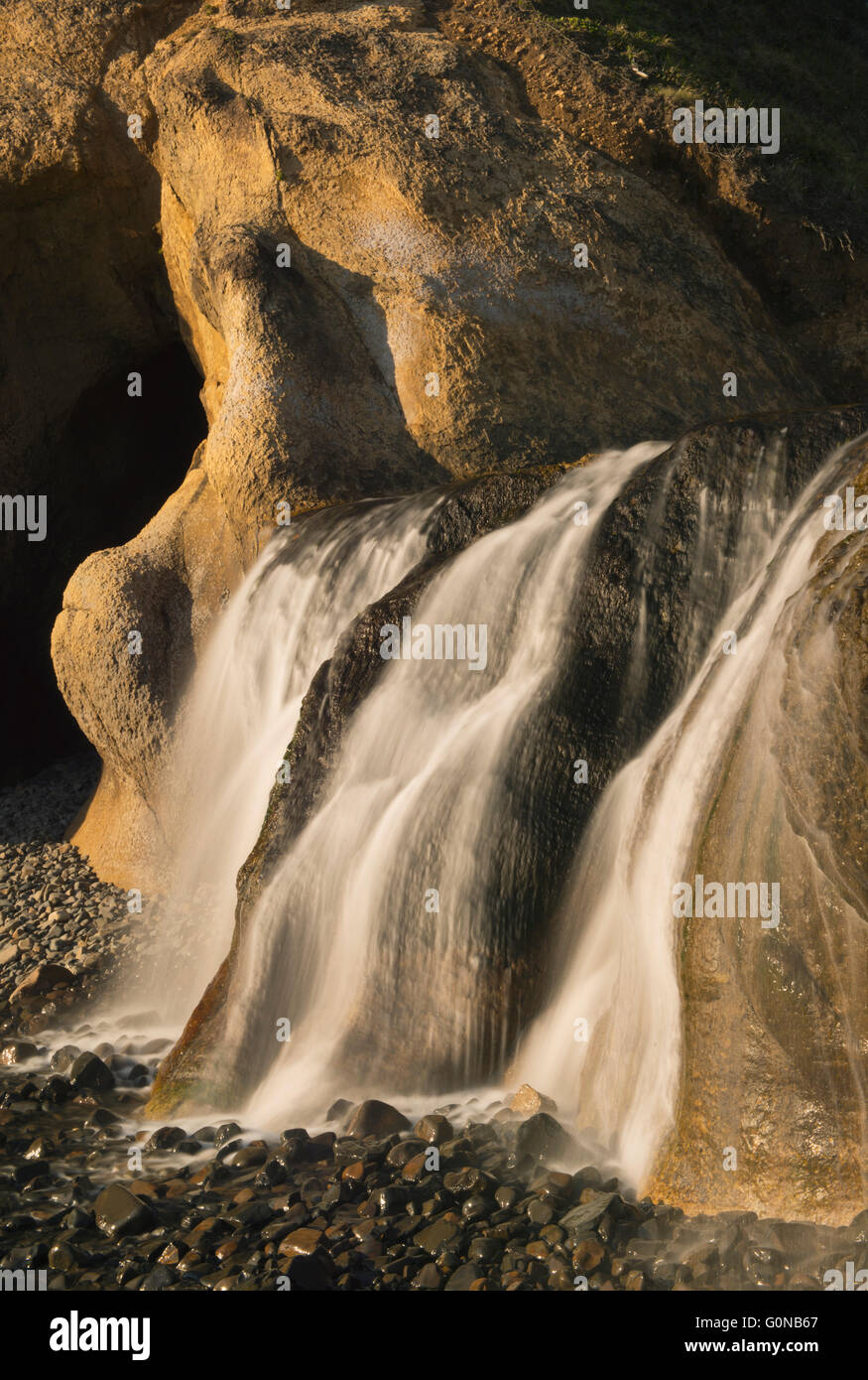 Waterfall on beach, Hug Point State Park, Oregon Coast Stock Photo