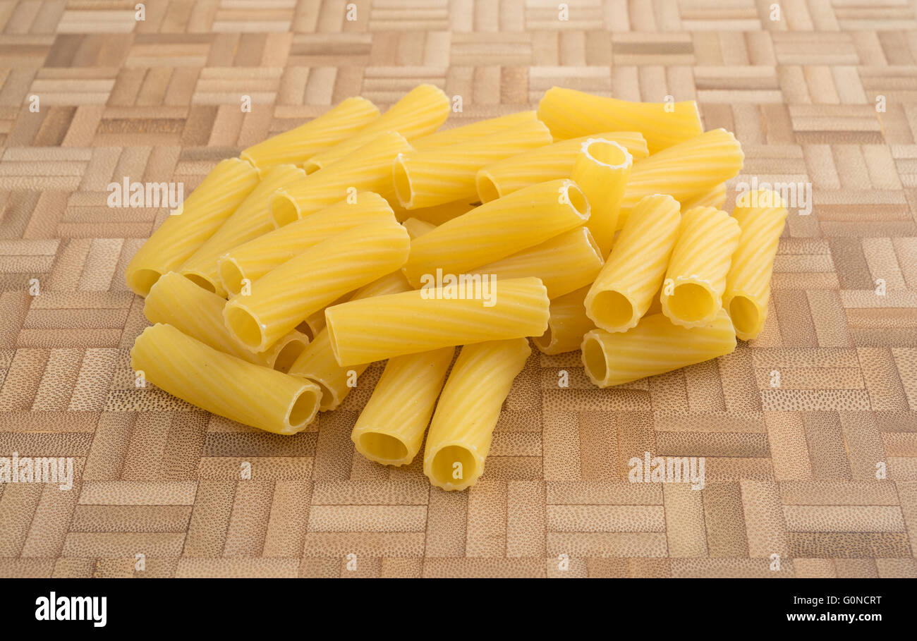 A portion of rigatoni pasta on a wood cutting board. Stock Photo