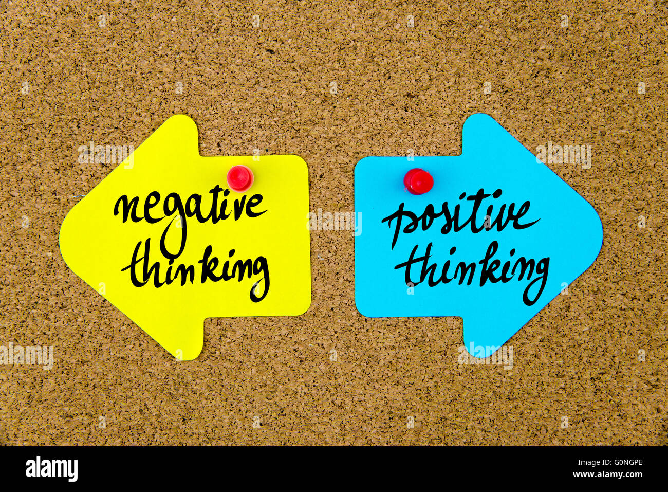 Message NEGATIVE THINKING versus POSITIVE THINKING on yellow and blue paper notes as opposite arrows pinned on cork board with thumbtacks. Choice conceptual image Stock Photo