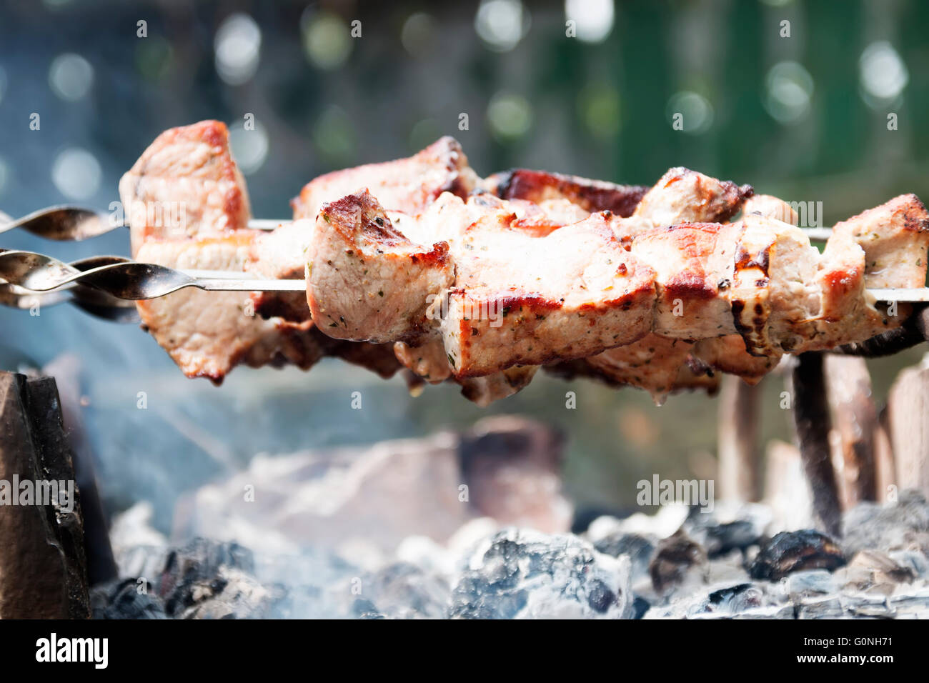 Smoky grilling the marinated pork meat shashlik. Stock Photo