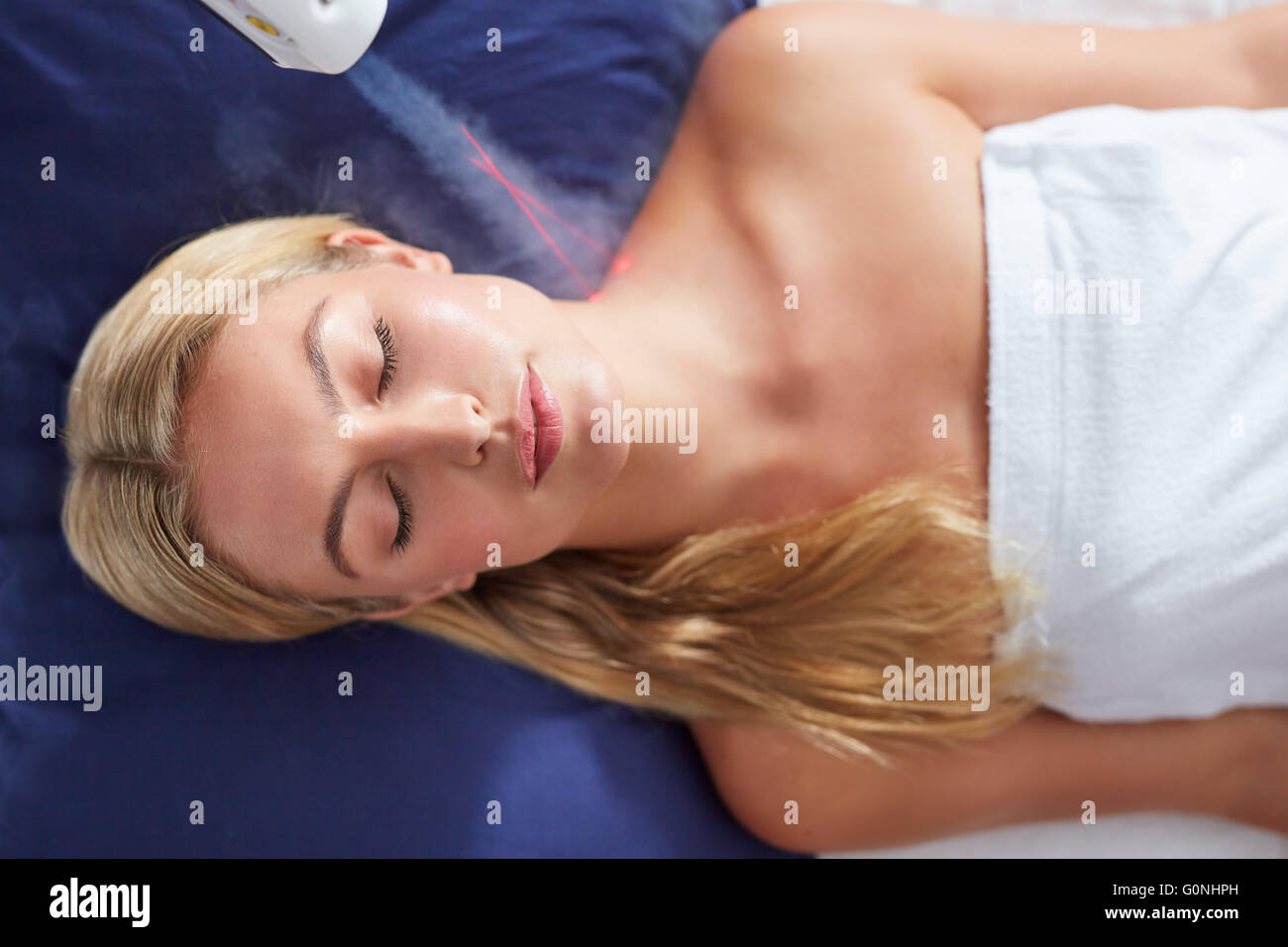 Localized cryotherapy session to the neck of young woman. Ice cold nitrogen vapors applied to the neck and shoulders. Stock Photo