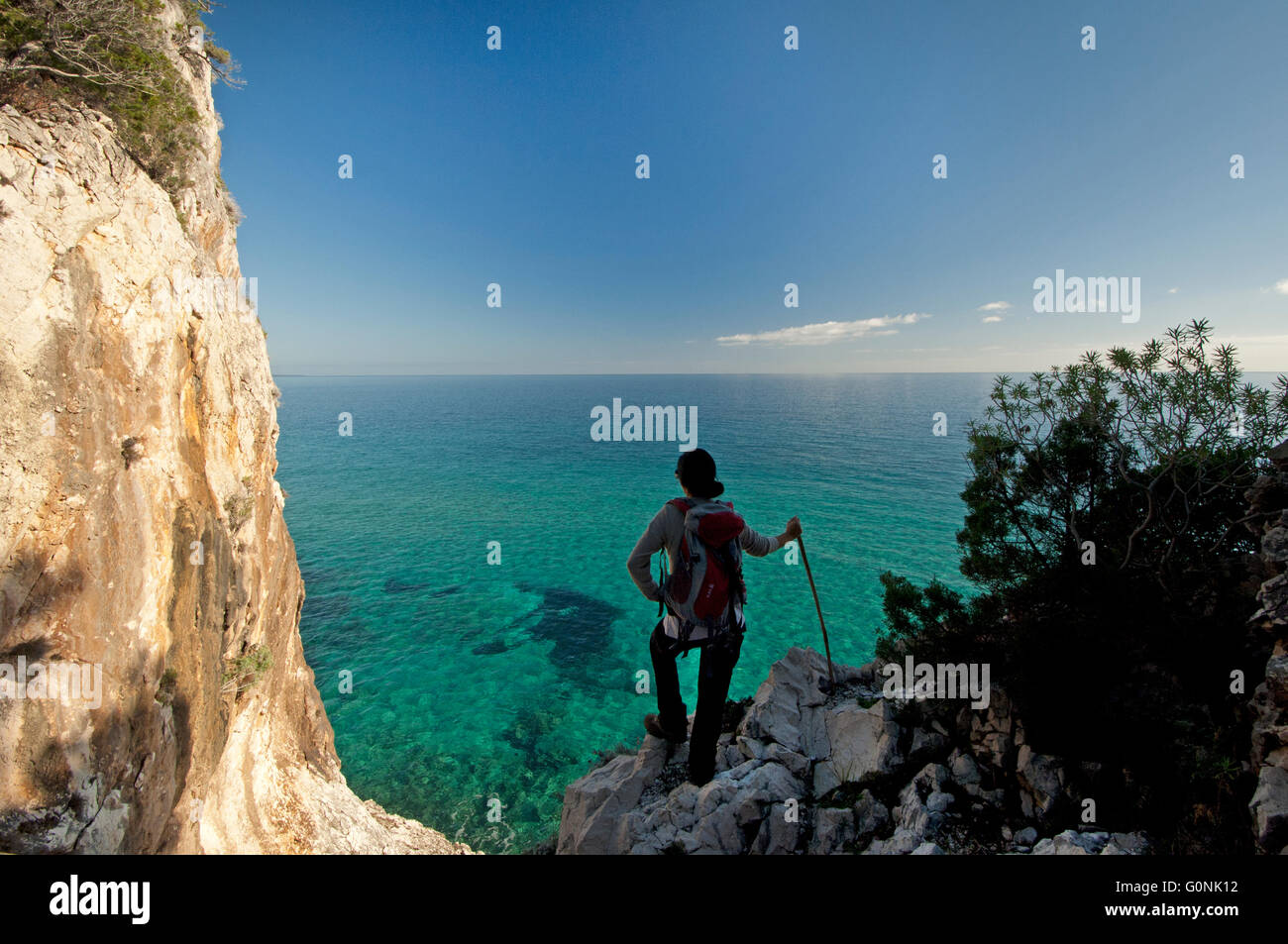 Baunei, Sardinia, Italy, 12/2015. Woman watching the sea along the famous Selvaggio Blu trekking route in the Ogliastra coast. Stock Photo