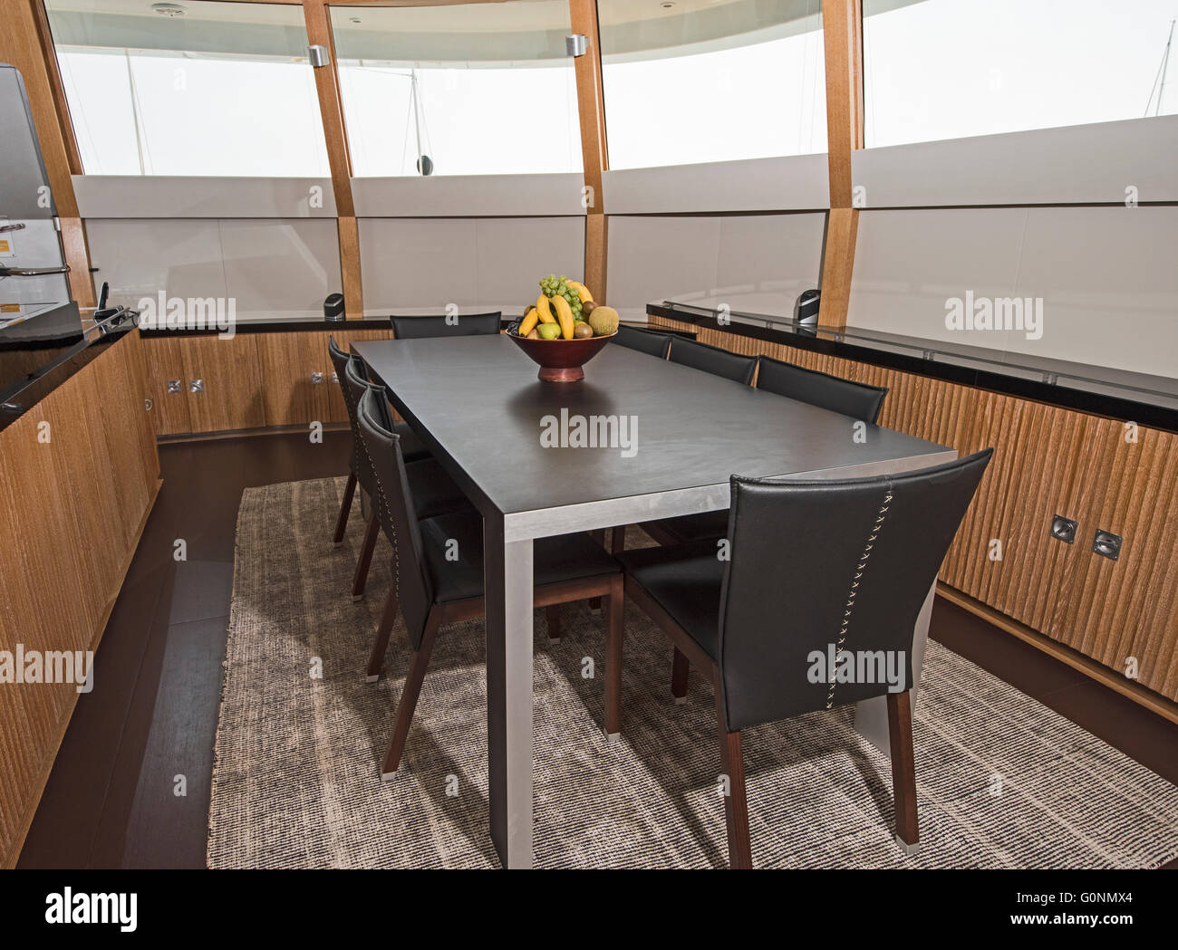 Dining area with table and chairs on large luxury motor yacht Stock