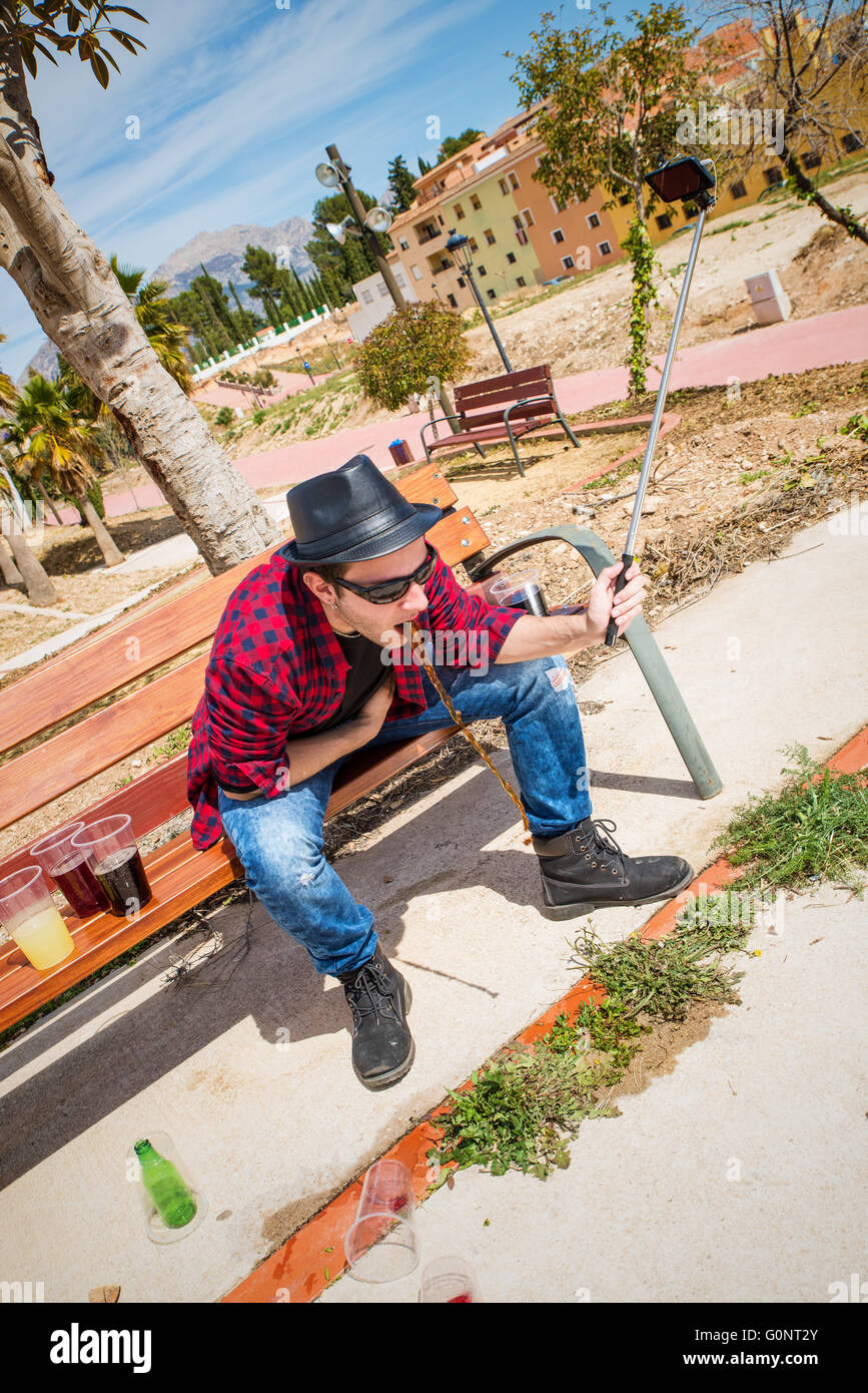 Guy throwing up on a park bench while taking a selfie Stock Photo Alamy