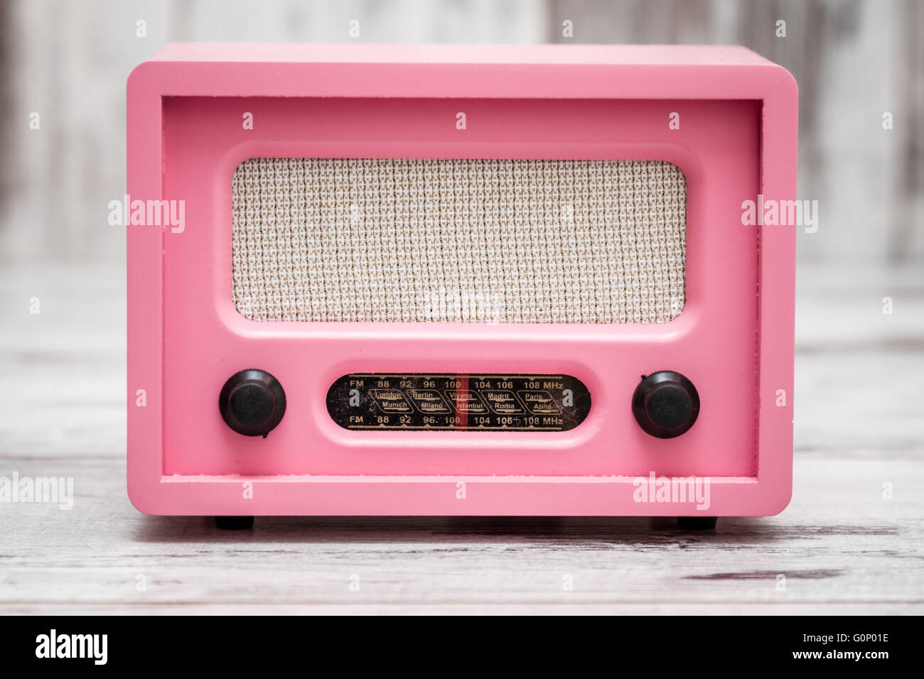 Pink radio with retro look on white wooden background Stock Photo - Alamy