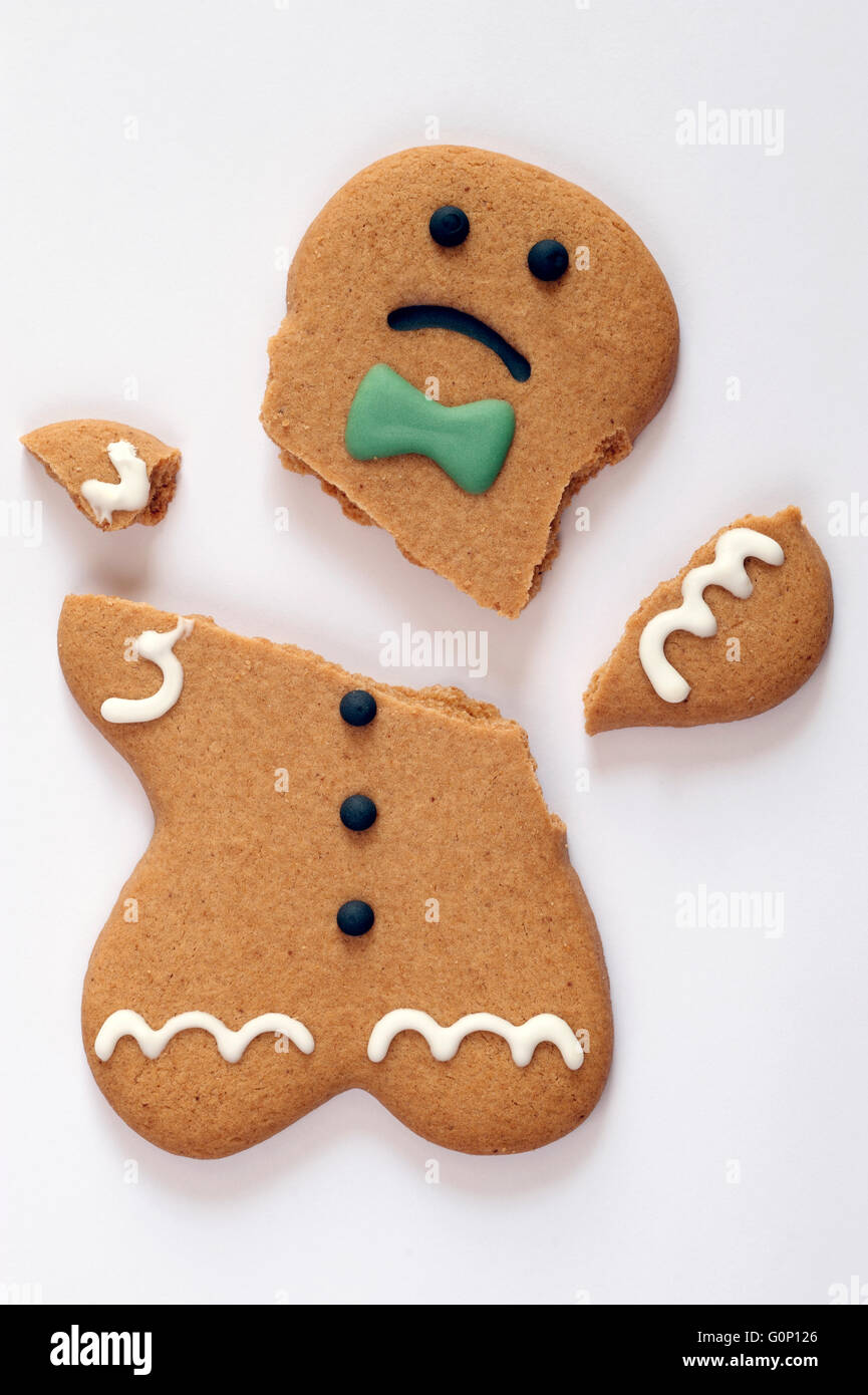 broken gingerbread man with unhappy looking face on white background Stock Photo