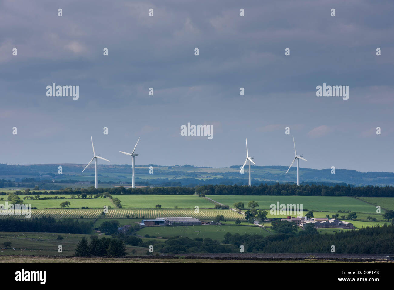4 giant wind turbines (eyesore?) tower over farmland fields in scenic countryside - Knabs Ridge wind farm near Harrogate, North Yorkshire, England. Stock Photo