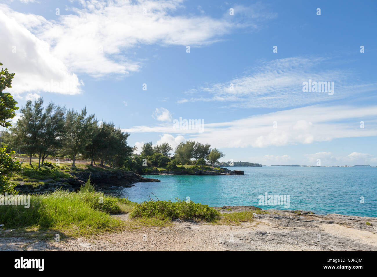 Bermuda coast with aqua blue tropical waters and rock formations complete with small caves. Stock Photo