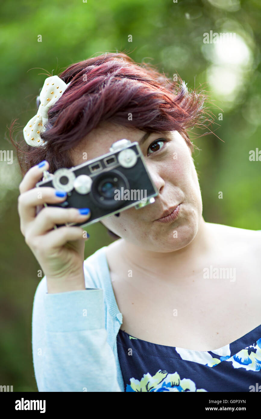 Female Photographer Shooting a vintage slr camera outdoors. Stock Photo