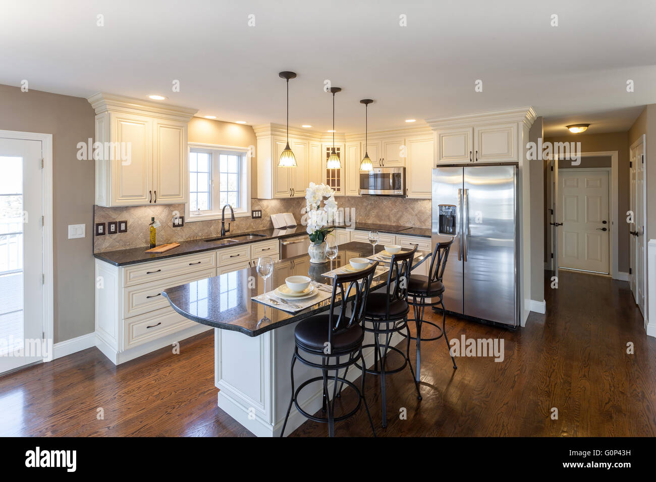 Beautiful staged kitchen room in a modern house with granite countertops and antique finished cabinets. Stock Photo