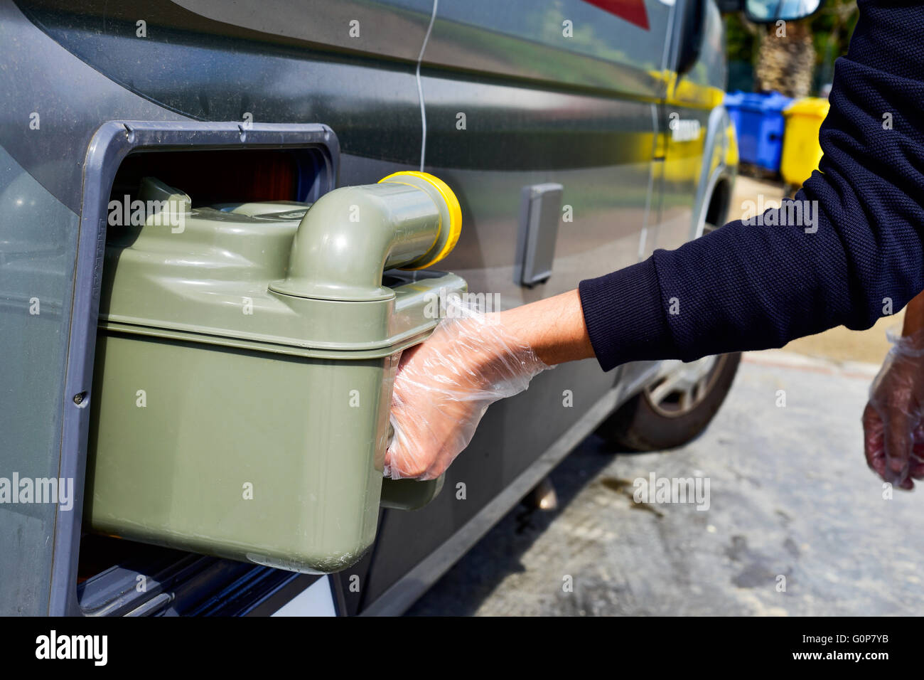 closeup of a young man removing the sewage tank of a campervan Stock