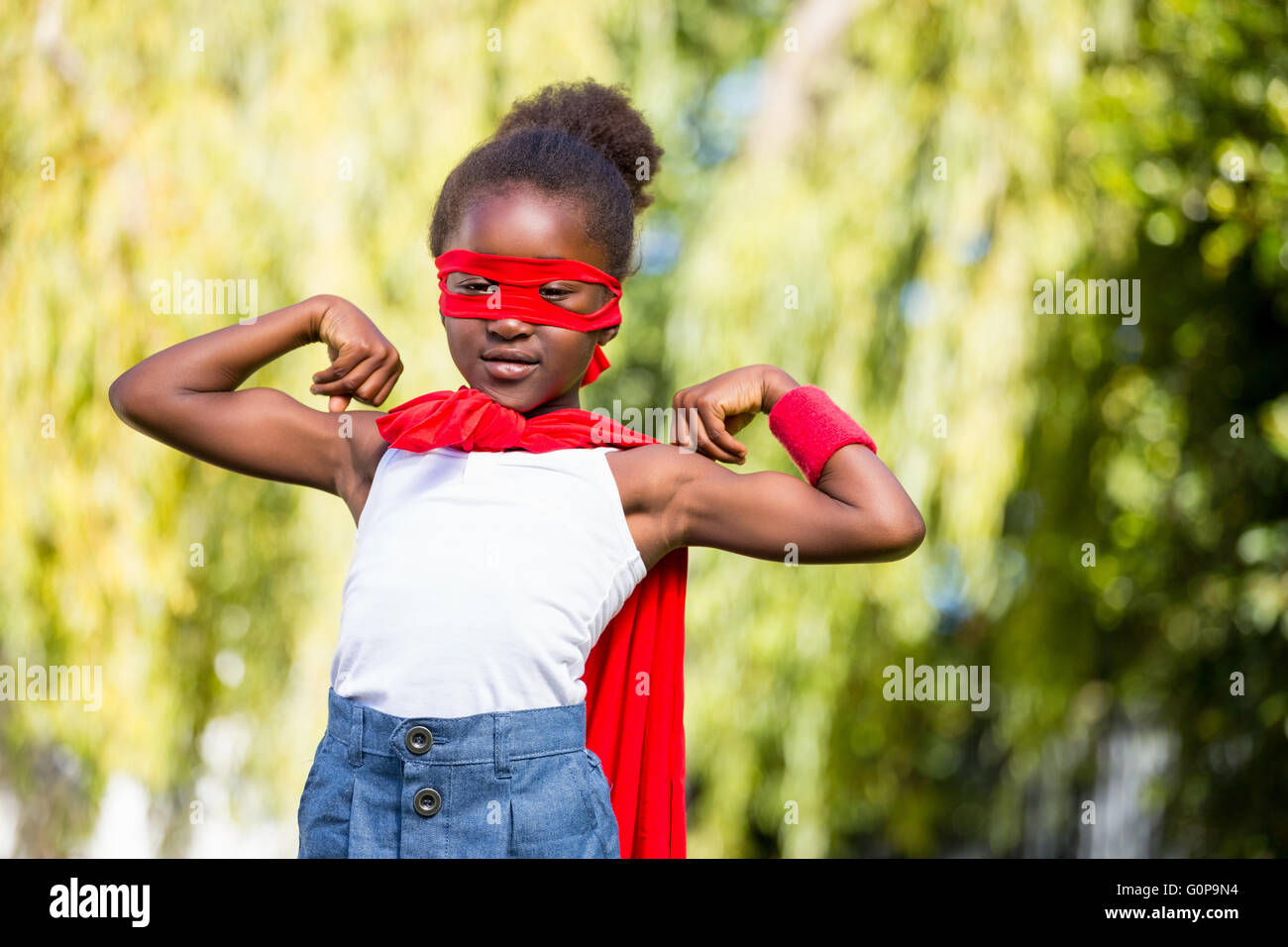 Cute mixed-race girl wearing a fancy dress and showing her biceps Stock Photo