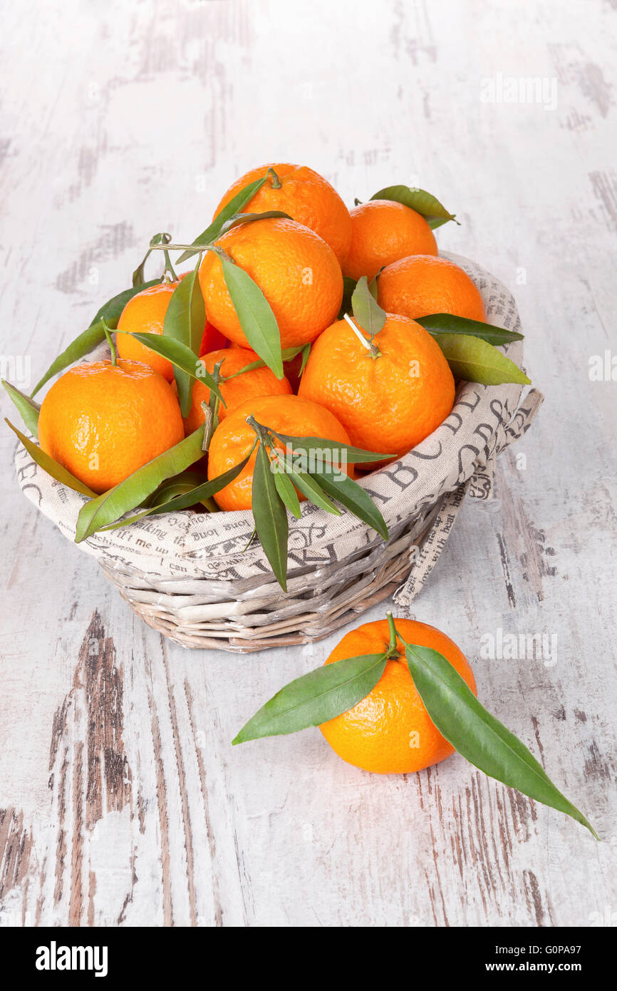 Mandarine fruit in white wooden basket on white wooden table. Provence style. Stock Photo