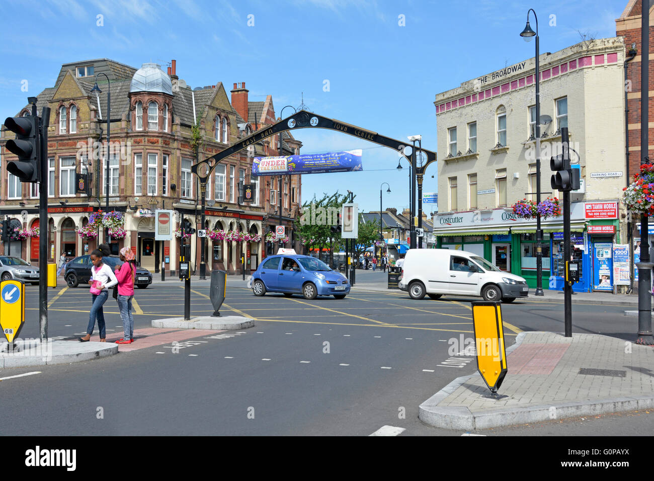 East Ham multicultural London Borough of Newham street scene & arch cars at traffic lights junction of High Street North & Barking Road England UK Stock Photo