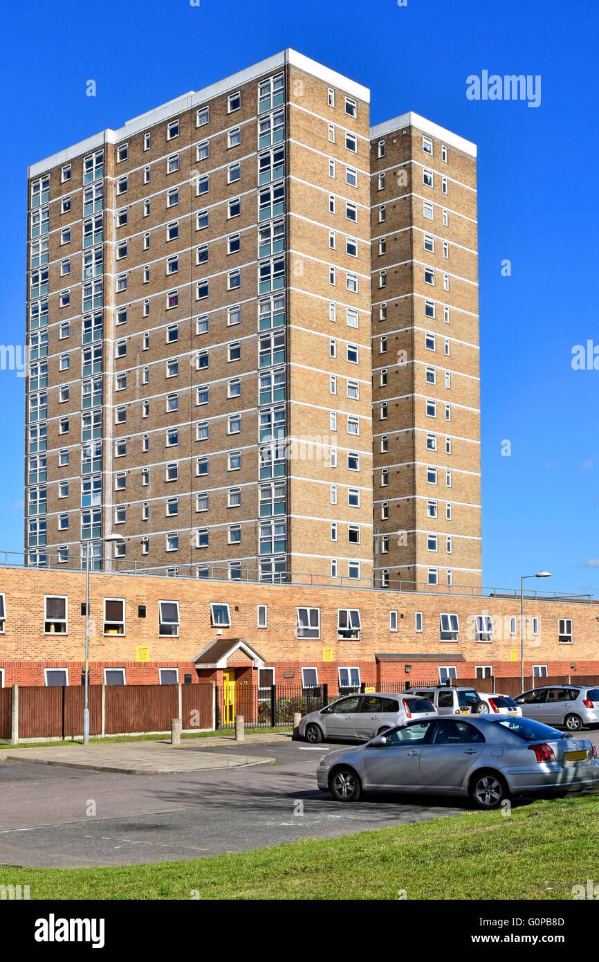Brick built high rise housing block of flats with adjacent low rise homes and car park Becontree Heath East London England UK Stock Photo