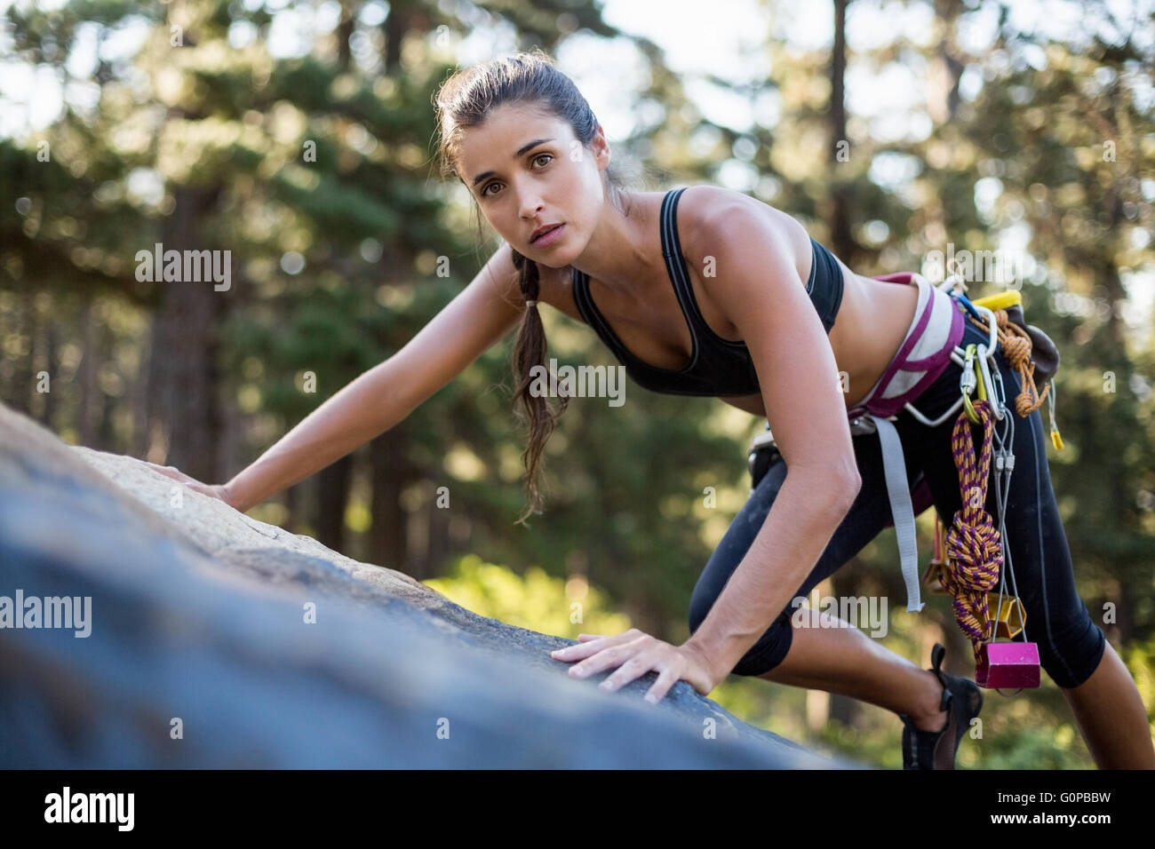 Woman rock climbing and looking the camera Stock Photo