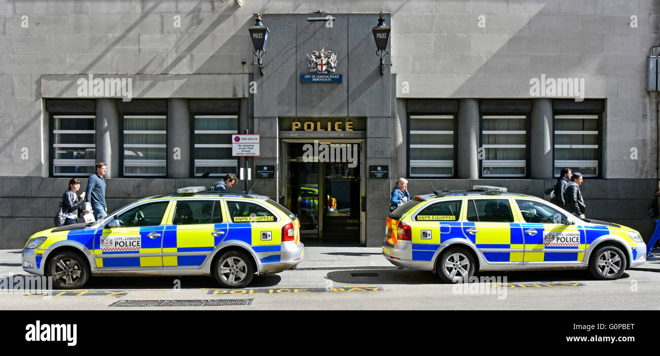 Police station UK public entrance & blue lamps Bishopsgate City of London England & police cars parked outside with unconnected passers-by on pavement Stock Photo