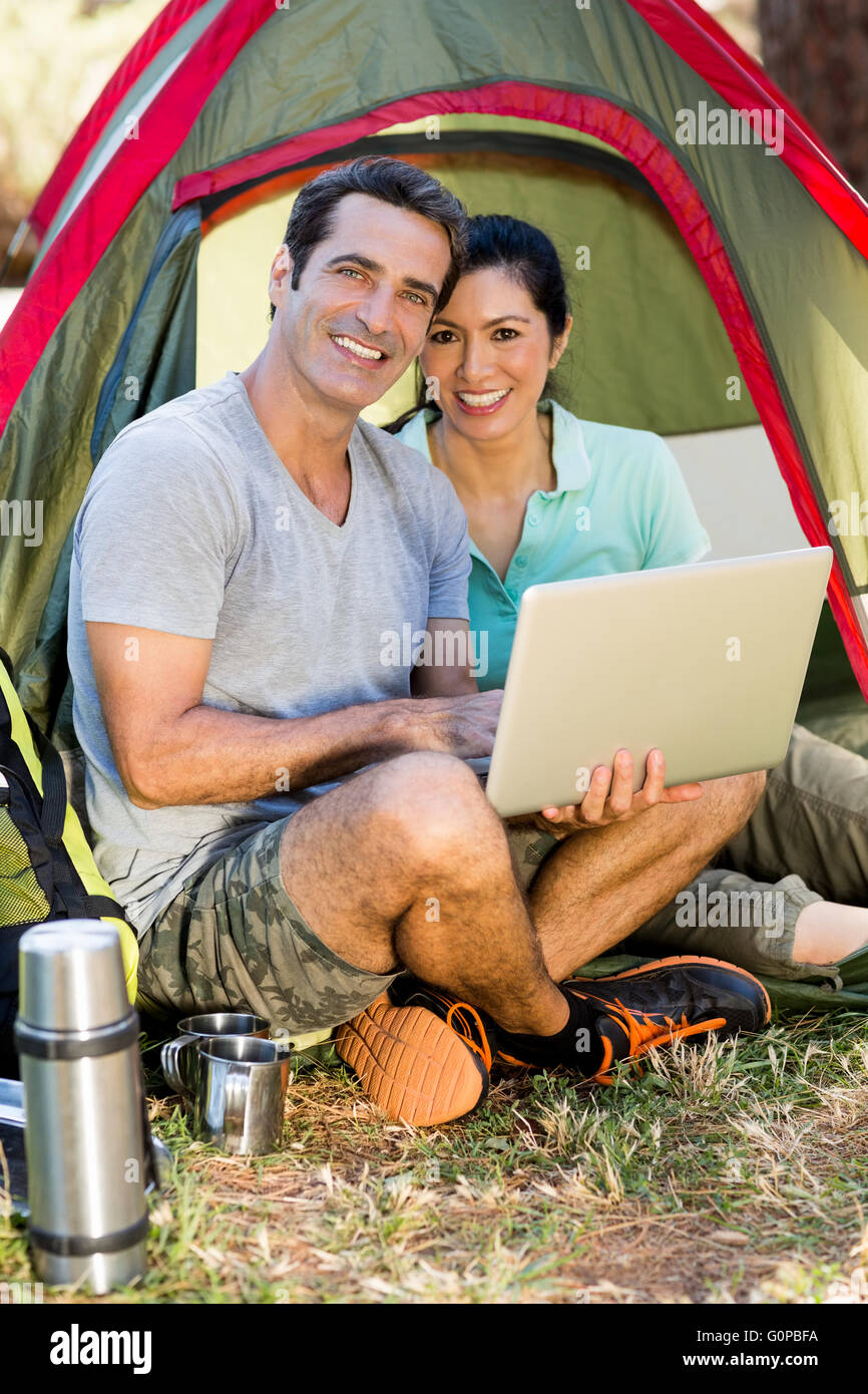 Couple smiling and holding a laptop Stock Photo - Alamy