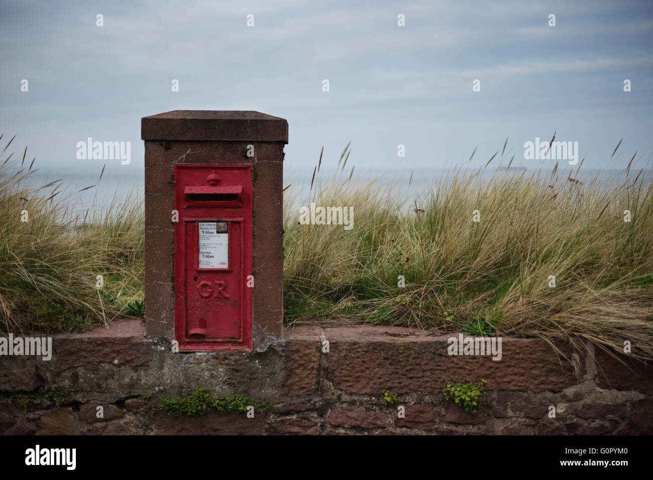 A traditional old red King George post box by the beach in North Berwick, Scotland. Stock Photo