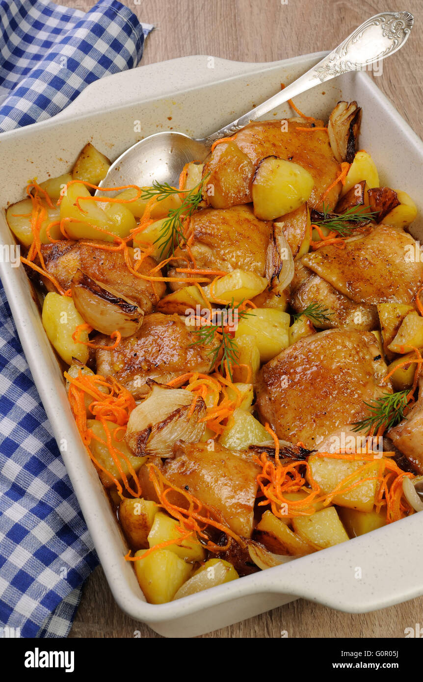 roast chicken with potatoes and vegetables in ceramic roasting pan