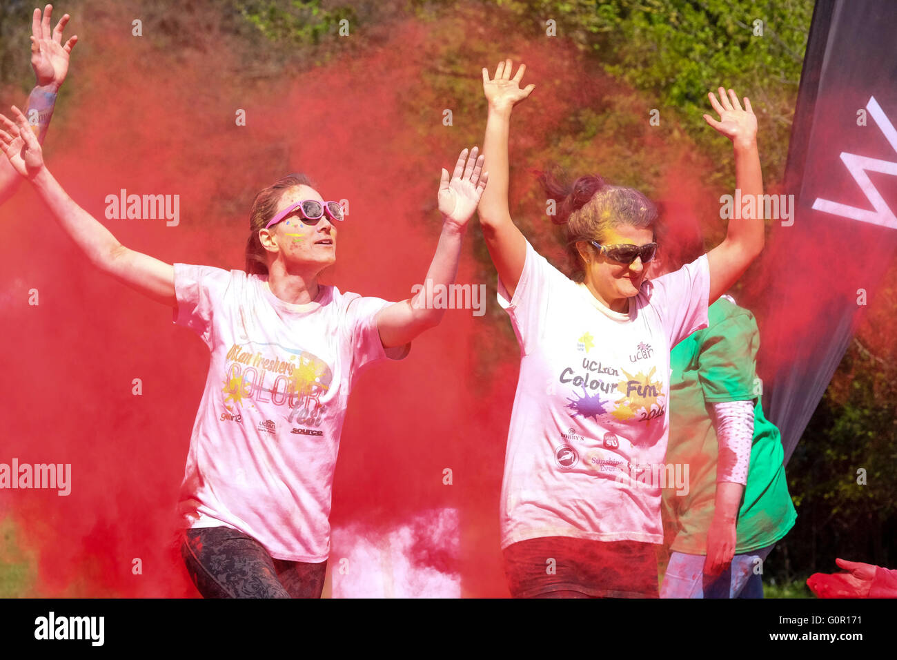 Runners taking part in a charity colour run at the University of Central Lancashire in Preston are pelted with ed Paint Powder Stock Photo