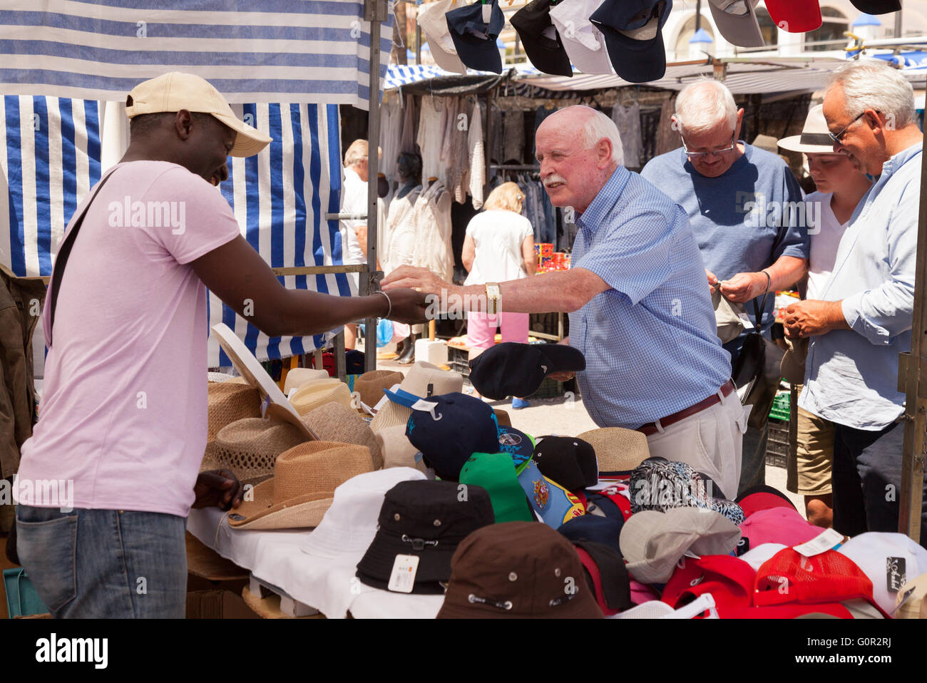 A male tourist buying a hat from a hat stall, Estepona market, Costa del Sol, Andalusia, Spain Europe Stock Photo