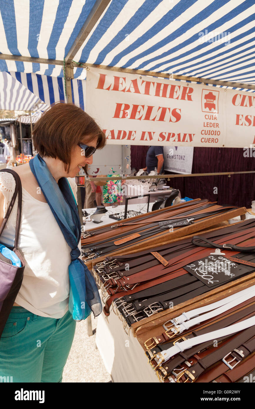 Woman buying leather belts at a leather belt stall, Estepona market, Costa del Sol, Andalusia Spain Europe Stock Photo