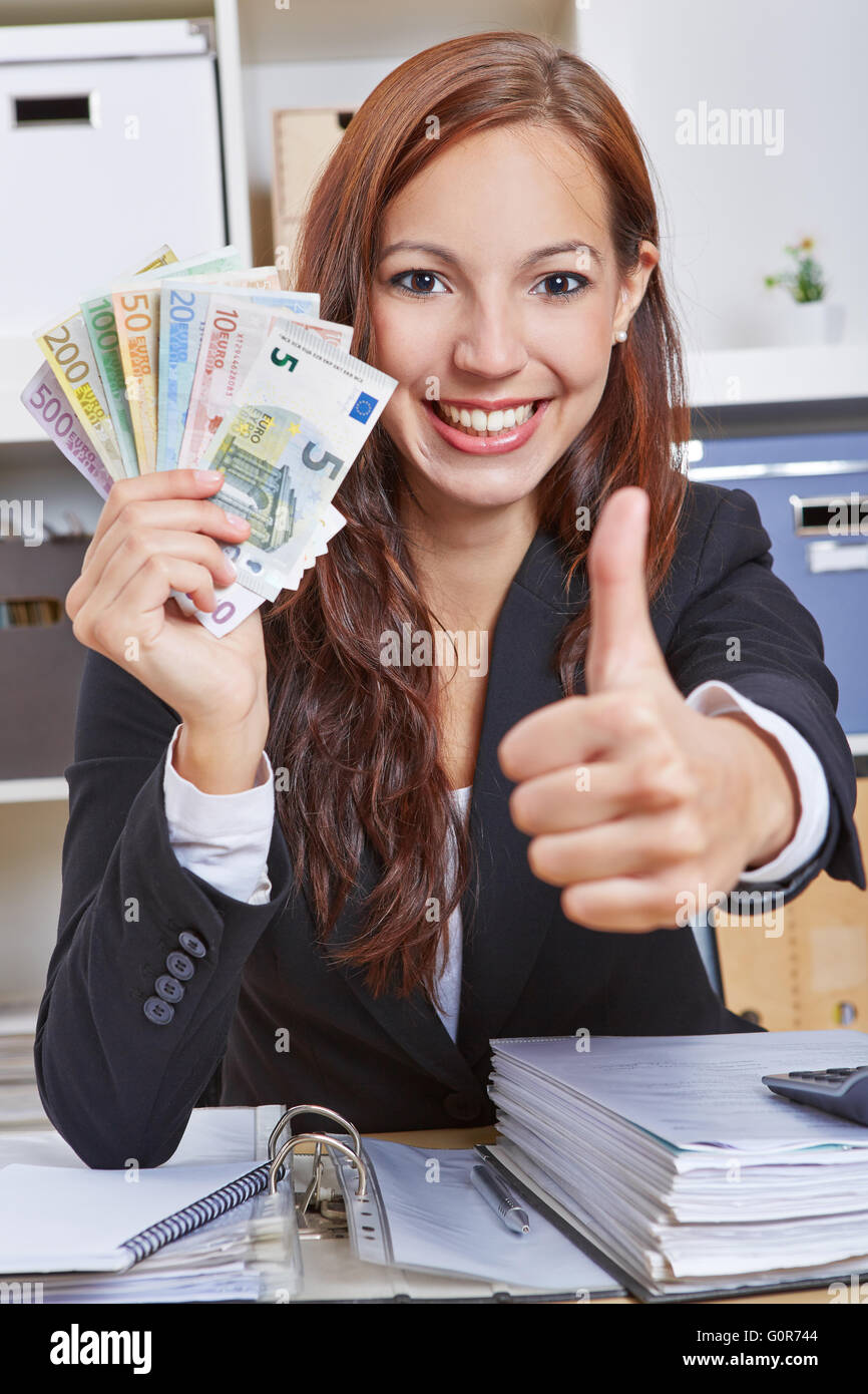Happy smiling business woman in office with Euro money holding thumbs ...