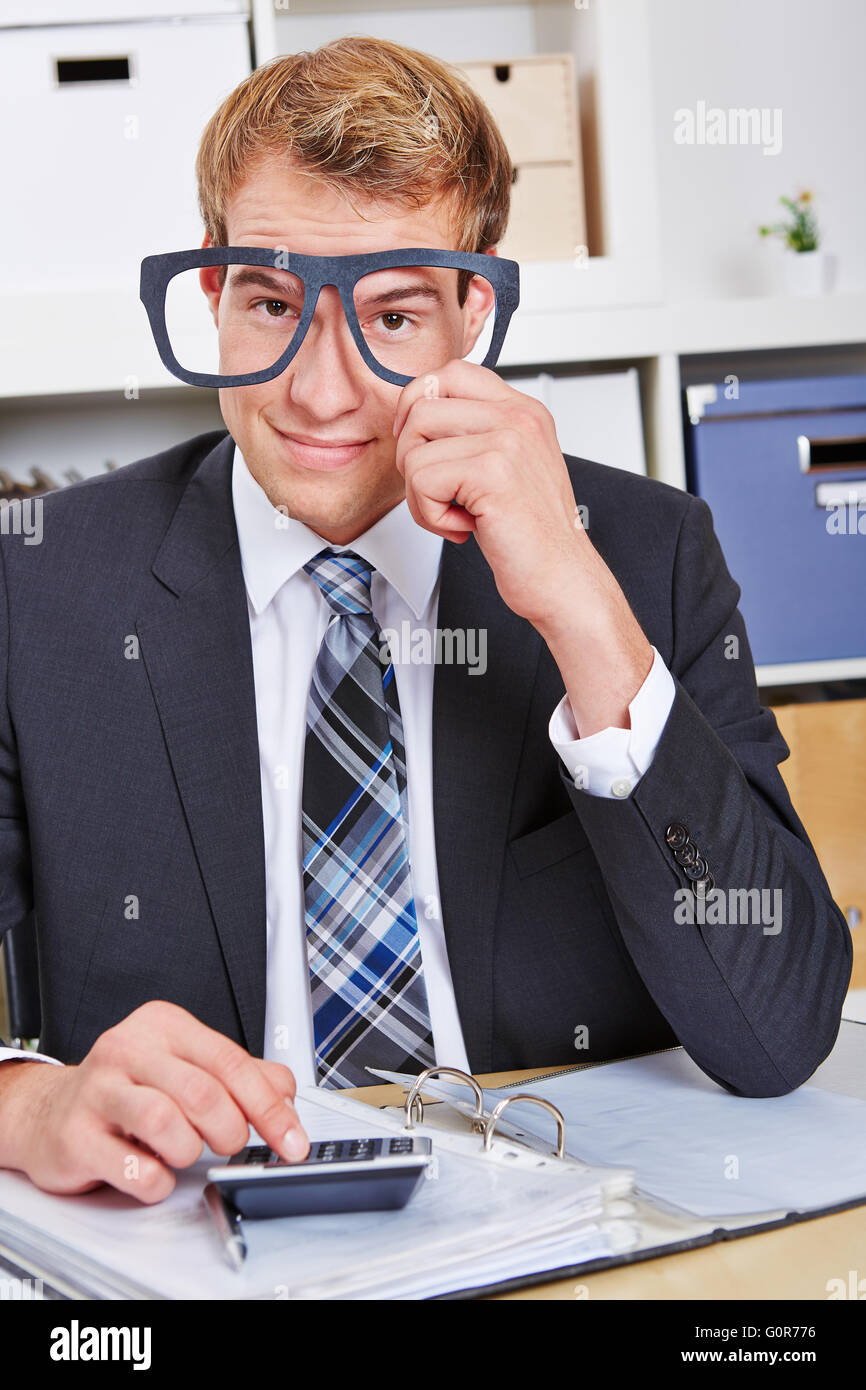 Smiling business man holding nerd glasses in front of his face in the office Stock Photo
