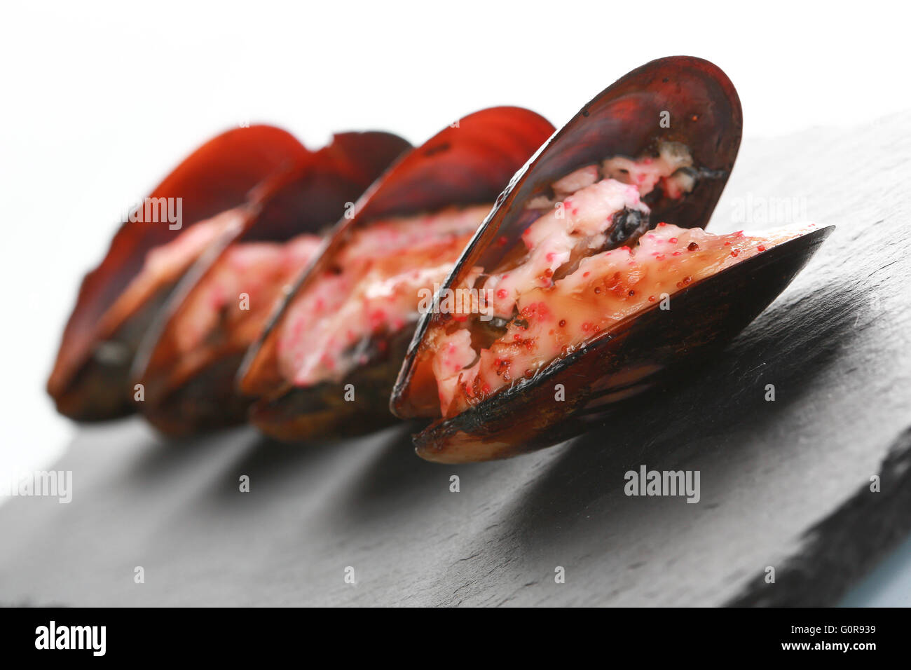 mussels in their shell on a black slate plate Stock Photo