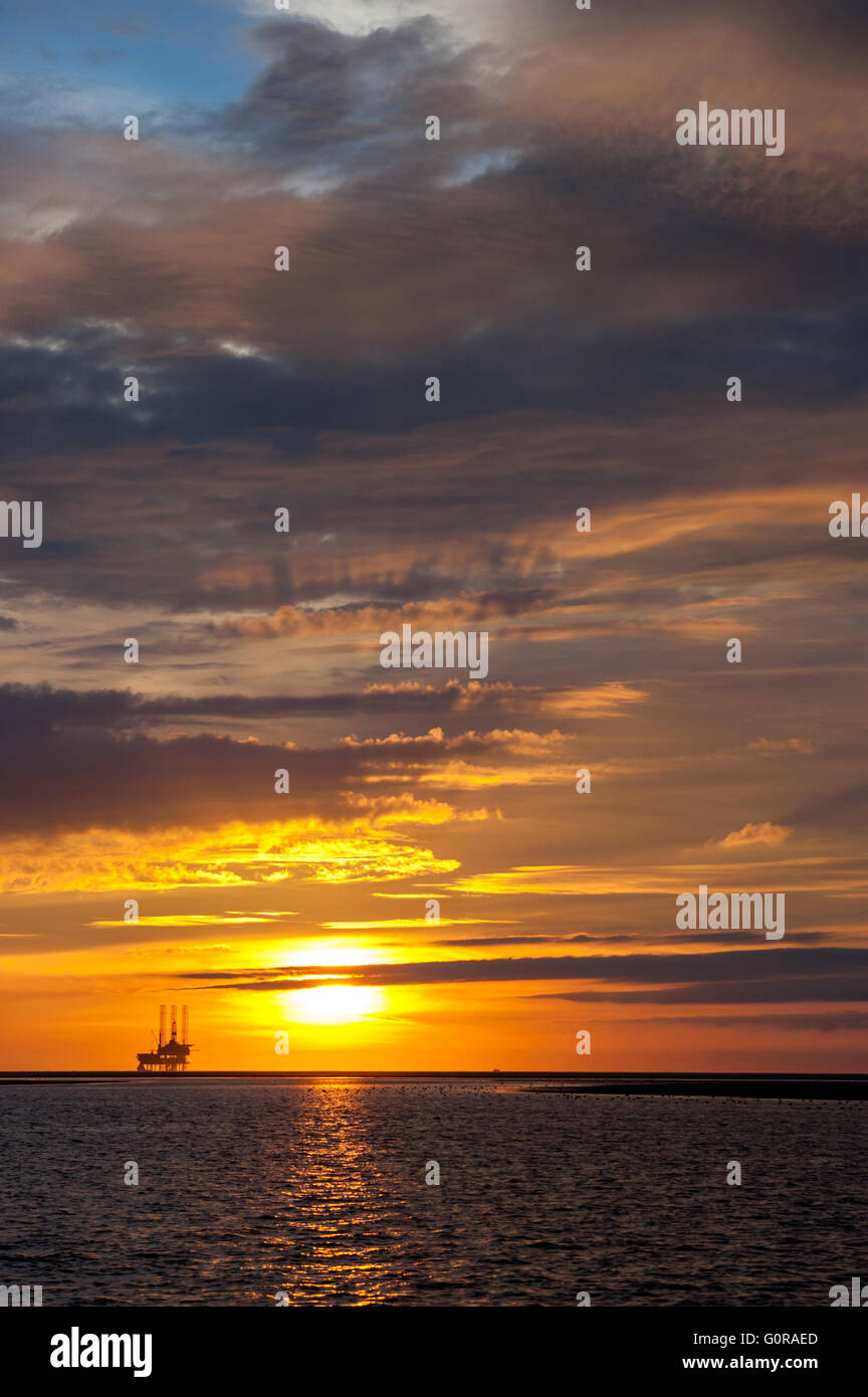 Offshore oil and gas rig platform at sunset on the North Sea north of the Netherlands Stock Photo