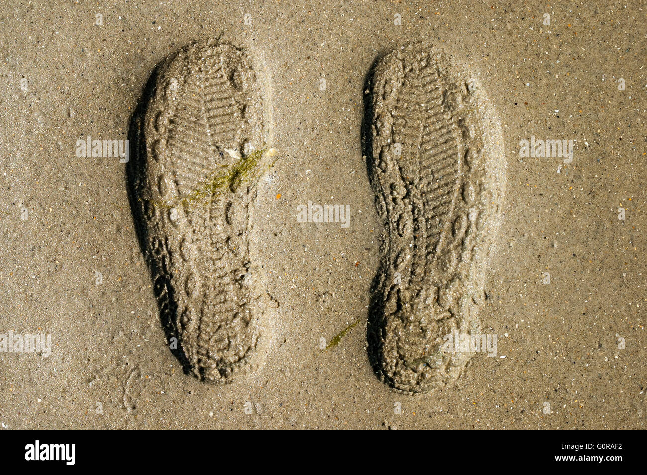 Prints of shoe soles in the sand Stock Photo