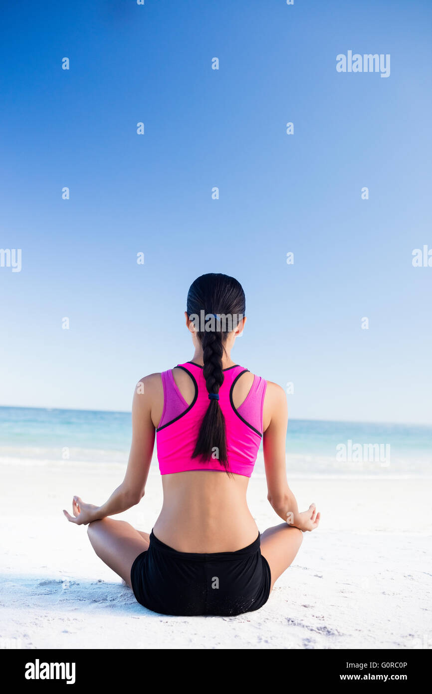 Woman doing yoga on the beach Stock Photo