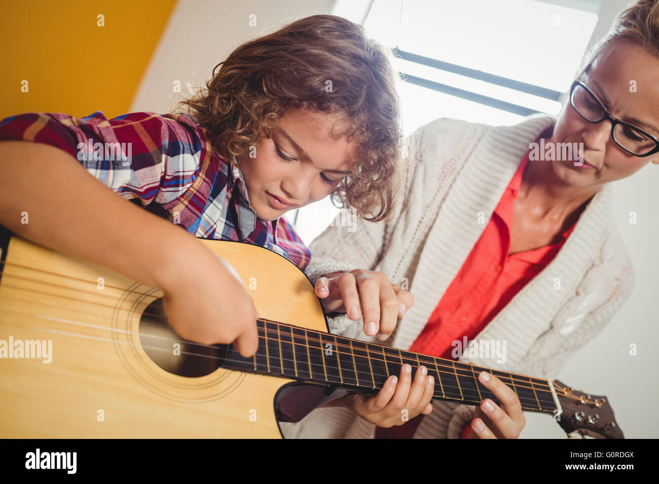 Boy learning how to play the guitar Stock Photo