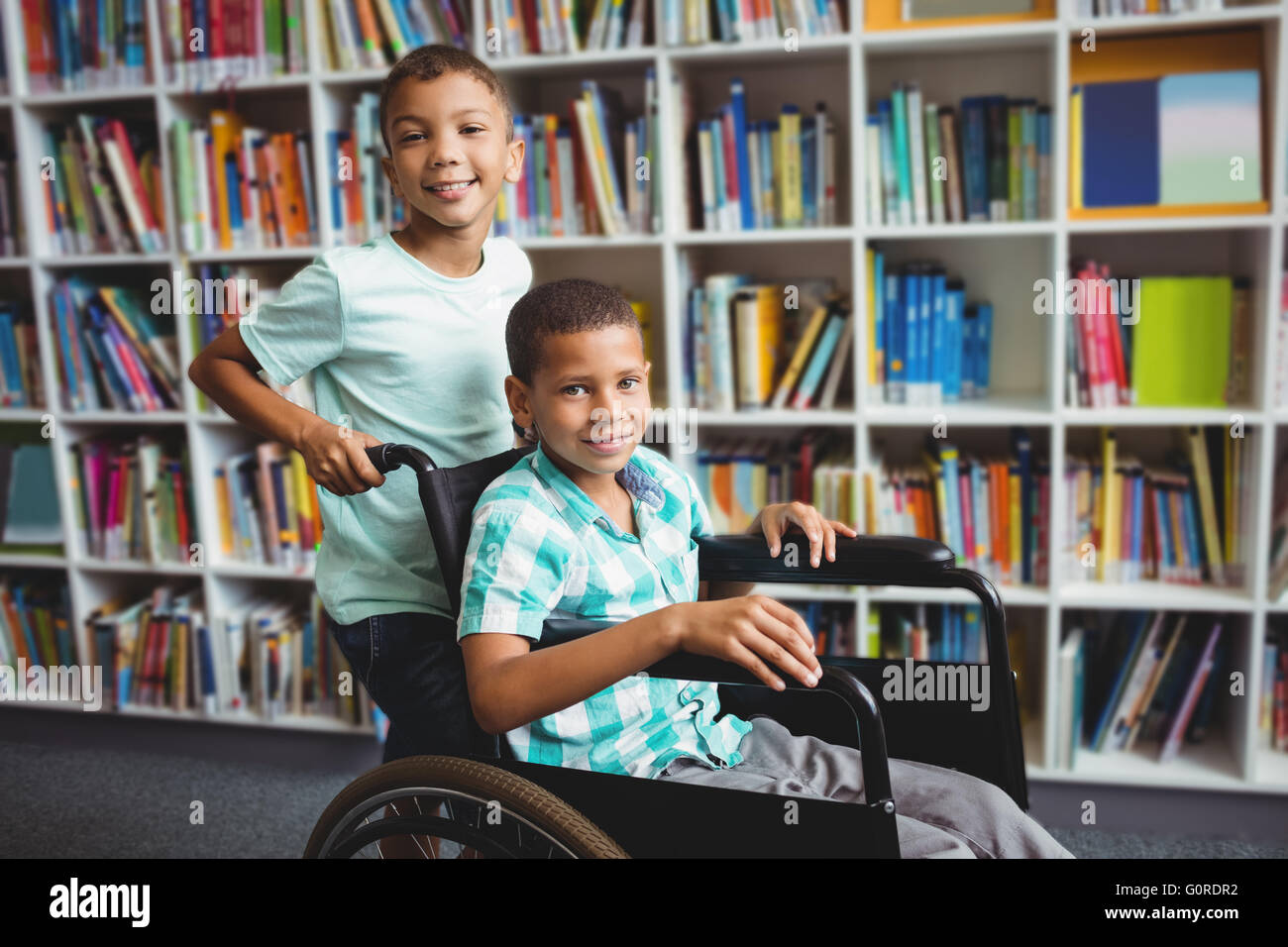 Boy pushing the wheelchair Stock Photo