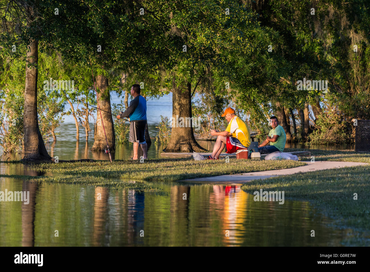 Three Hispanic men fishing by a lake in the weekend. Houston, Texas, USA. Stock Photo