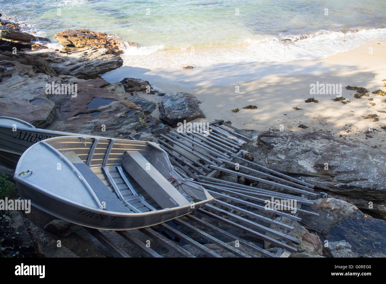 Two aluminium dinghies on a wooden boat ramp at Gordons Bay, Sydney