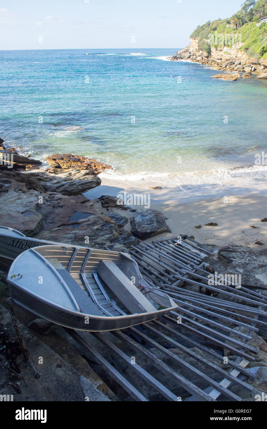 Two aluminium dinghies on a wooden boat ramp at Gordons Bay, Sydney