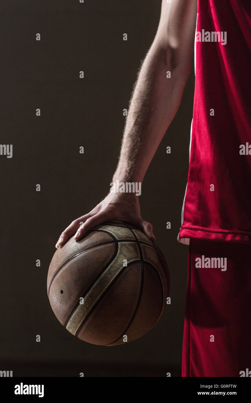 Close up on basketball held by basketball player Stock Photo