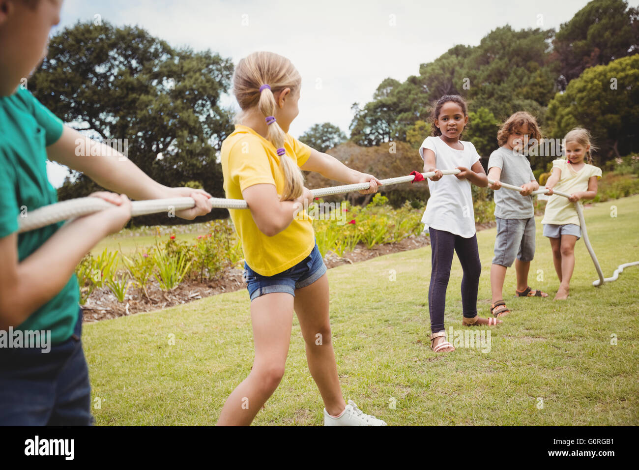 Children pulling a rope in tug of war Stock Photo