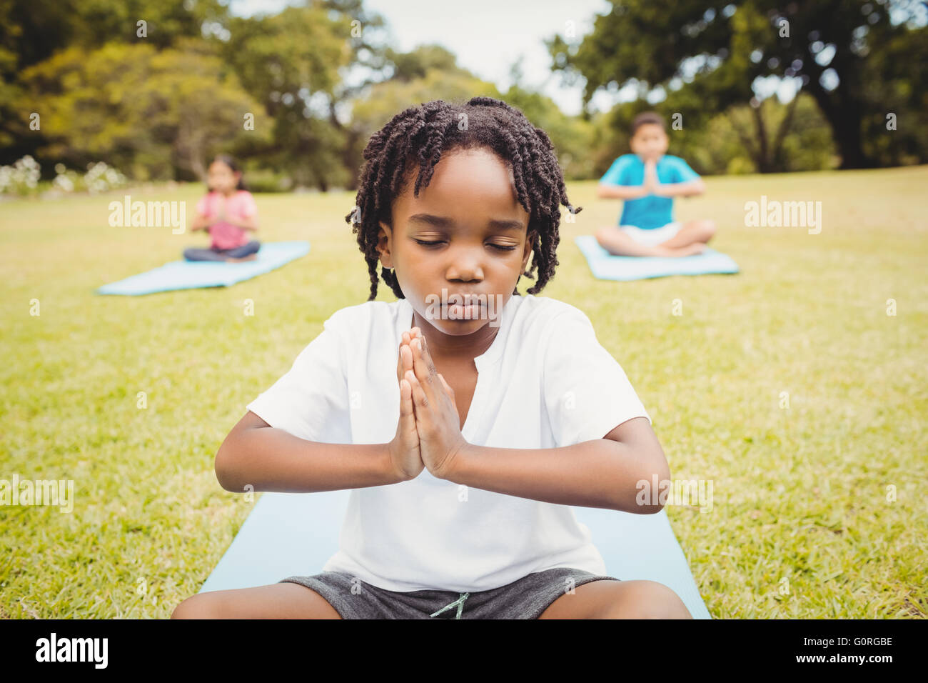 Portrait of child doing yoga with friends Stock Photo