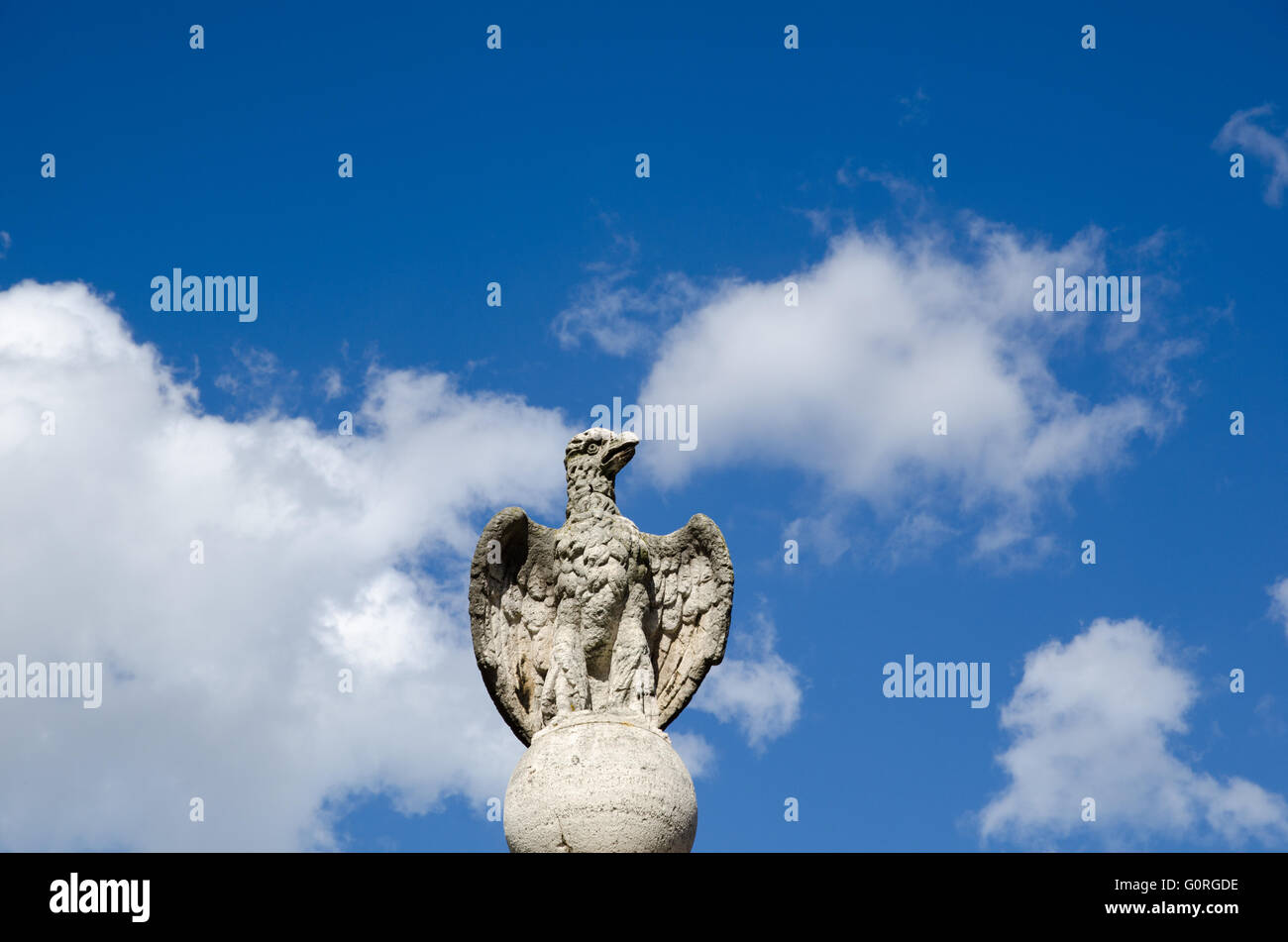 Ancient eagle statue at blue sky with white clouds in Rome, Italy Stock Photo