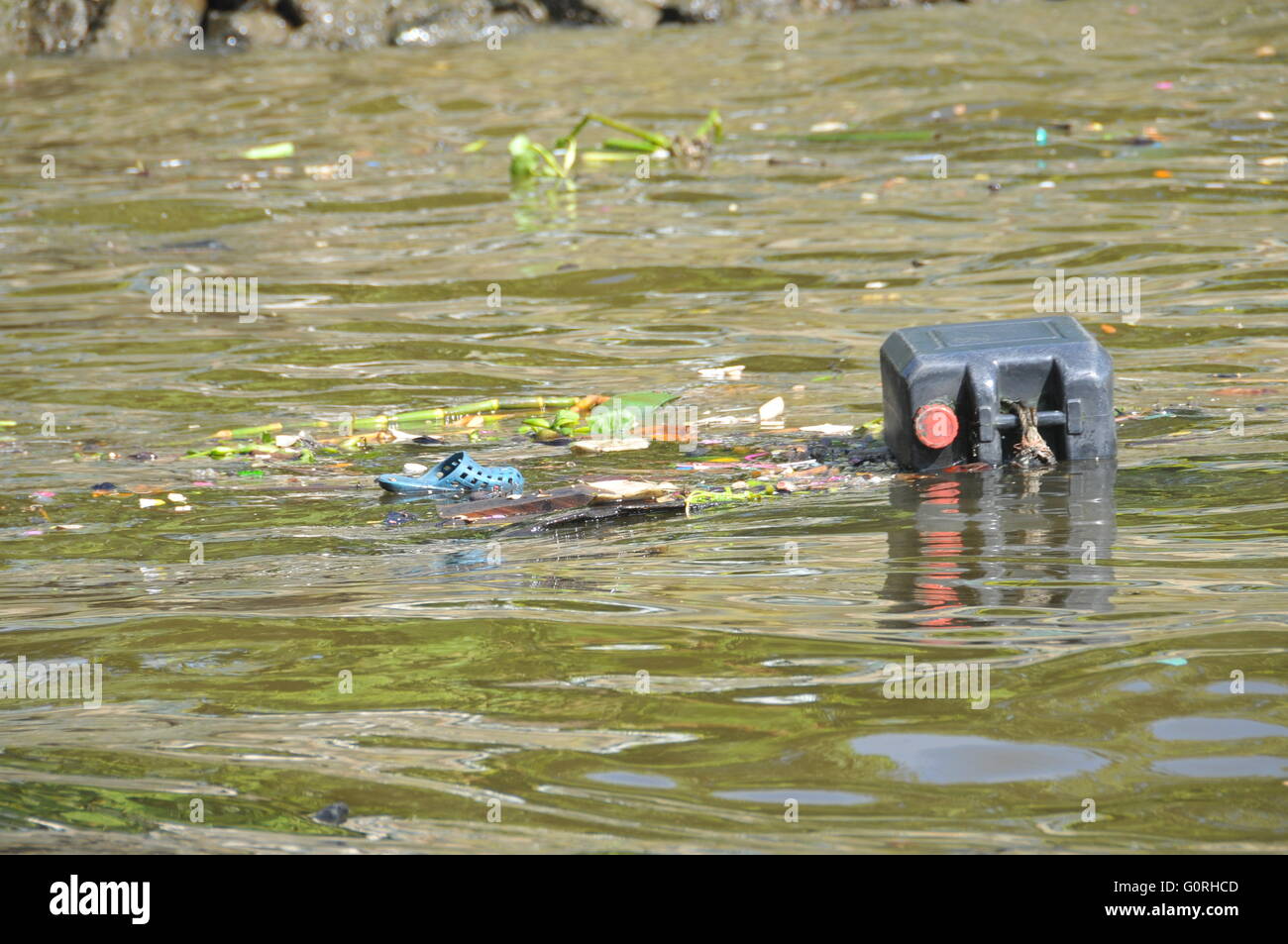 Plastic waste floating down a river causing pollution in a river in Bangkok, Thailand. Stock Photo